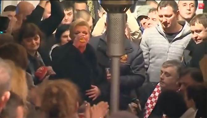 Otvoreno se stavlja na znanje da su dvije strane na zajedničkom zadatku,
a vidi se i podjela posla, u kojoj šatoraši obavljaju grube rušilačke
radove, a Kitarović daje politički softver u obliku sugestije da
promjene koje se valjaju Savskom imaju američku podršku. (ytb-prtsc)<br>