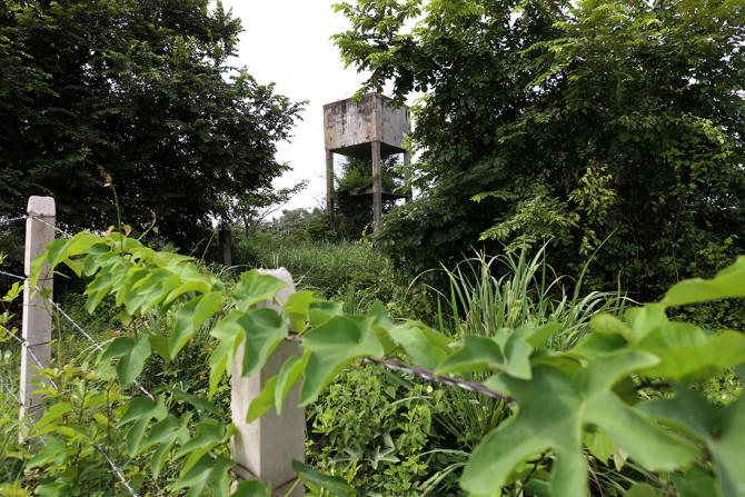 The only thing that remains from Plan Bonito village is a water tower now surrounded by high grass.